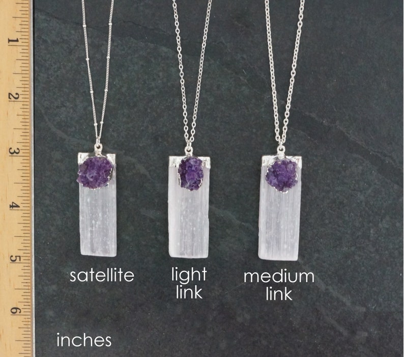 May include: Three selenite crystal pendants with amethyst points, each on a silver chain. The pendants are labeled "satellite", "light link", and "medium link".