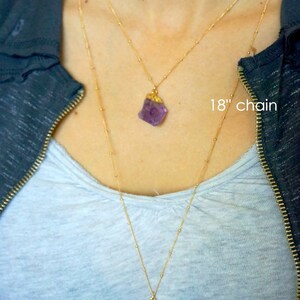 May include: Two gold chains with amethyst crystal pendants. The shorter chain is 18 inches long and the longer chain is 30 inches long.