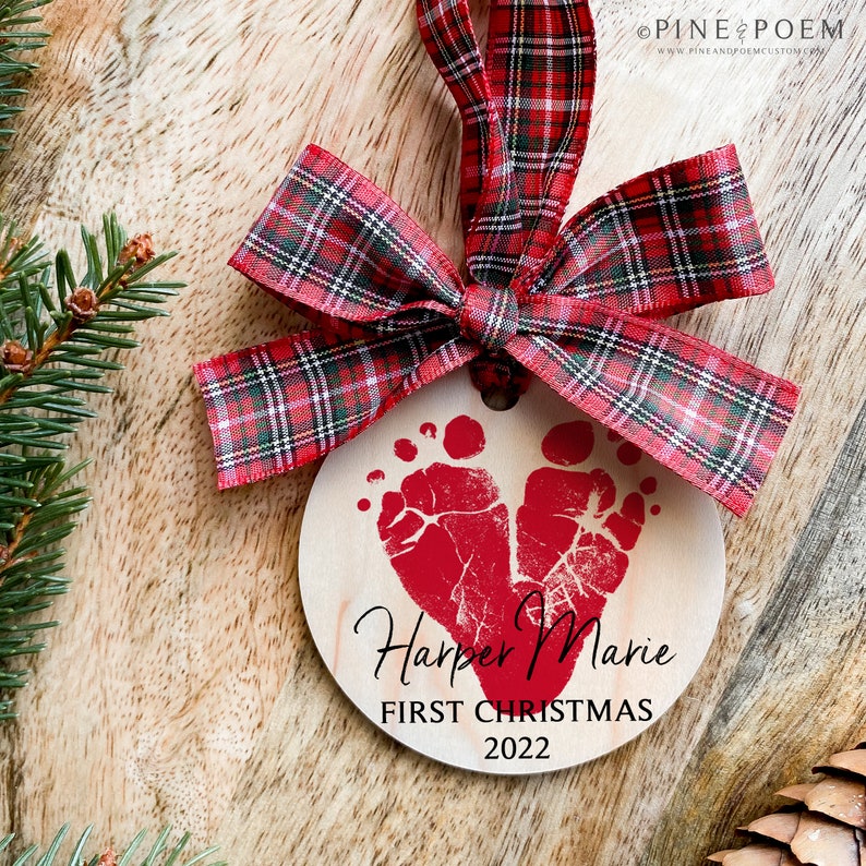 Personalized Baby Footprint Heart First Christmas Ornament. Wood ornament with red plaid ribbon, baby name, and first Christmas date. Farmhouse Christmas Gift for New Parents, Mom or Dad.