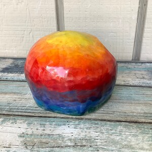 May include: A colorful, resin skull with a rainbow gradient of yellow, orange, red, blue, and green.
