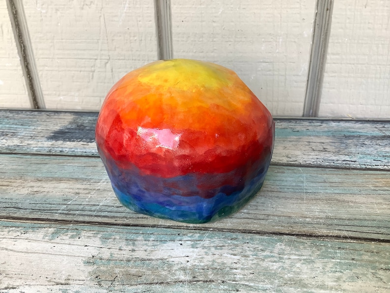 May include: A colorful, resin skull with a rainbow gradient of yellow, orange, red, blue, and green.