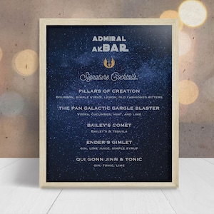 May include: A framed vertical sign with a dark blue starry background featuring the text Admiral Akbar Signature Cocktails and a list of drink names including Pillars of Creation, The Pan Galactic Gargle Blaster, Bailey's Comet, Ender's Gimlet, and Qui Gonn Jinn & Tonic.