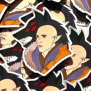 May include: A sticker featuring a cartoon illustration of a person with pointed ears and a wolf head. The person is wearing a blue and orange robe. The wolf head has red eyes and sharp teeth.