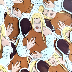 May include: A set of colorful stickers featuring a vampire couple embracing. The stickers are printed on white paper and have a glossy finish.