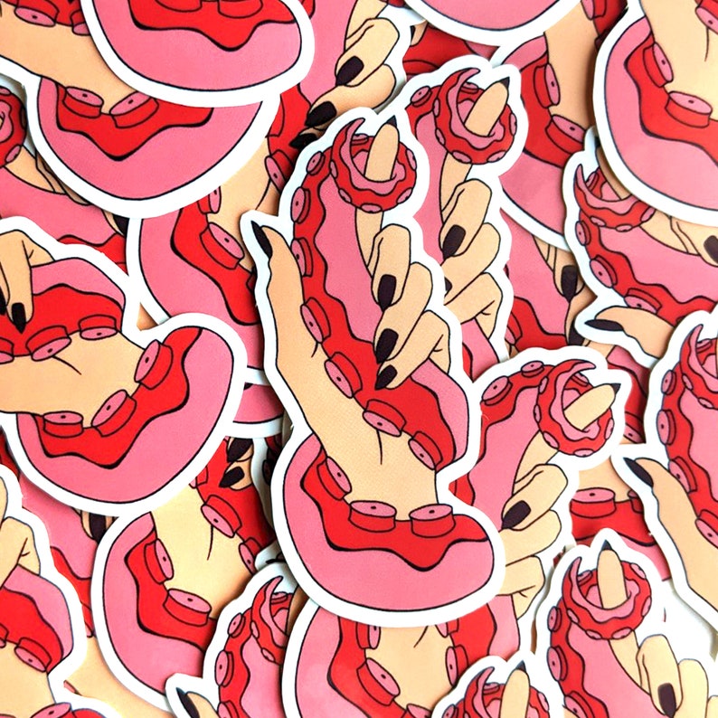 May include: A set of stickers featuring a hand holding an octopus with pink and red tentacles. The stickers are printed on white paper and have a glossy finish.