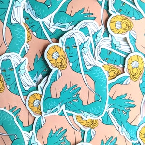 May include: A set of colorful stickers featuring mermaids with long flowing hair and tails. The stickers are in various poses, including swimming, holding a seashell, and looking at the viewer. The stickers are perfect for adding a touch of whimsy to any project.