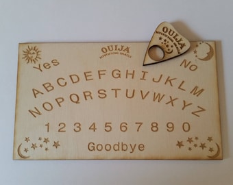 May include: A wooden Ouija board with a planchette. The board features the alphabet, numbers 1-9 and 0, the words "Yes", "No", and "Goodbye", and a crescent moon and stars.
