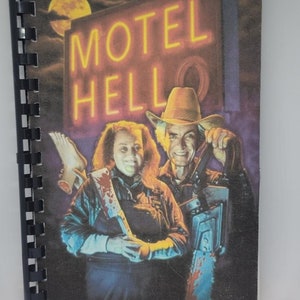 May include: A vintage horror movie poster featuring a man and woman holding a chainsaw and a cleaver. The poster has a neon sign that reads "Motel Hell" with a yellow moon in the background.