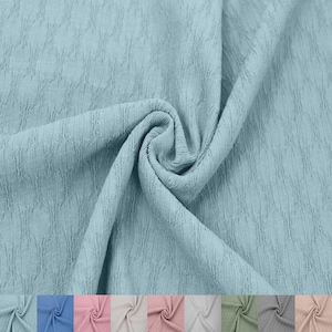 May include: A close-up of a light blue textured fabric. The fabric is soft and has a subtle pattern.