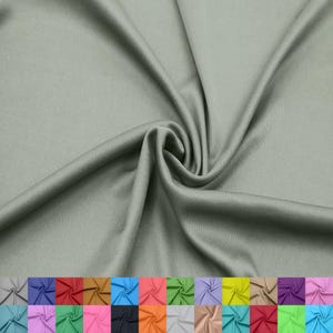 Puede incluir: Primer plano de una muestra de tela verde salvia con una textura suave y fluida. La tela está drapeada y doblada, creando sombras y reflejos. Una paleta de colores de varias telas se muestra en la parte inferior.