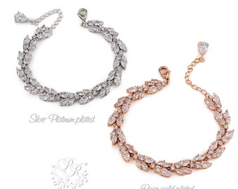 May include: Two delicate bracelets with a leaf design, one in silver platinum plated and the other in rose gold plated. Both bracelets are adorned with sparkling cubic zirconia stones.
