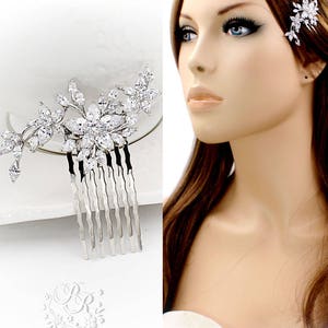May include: Silver bridal hair comb with a floral design featuring clear rhinestones. The comb has a row of teeth for easy placement in hair.