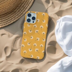 May include: A yellow phone case with a white floral pattern. The case has a camera lens cutout and a raised lip around the edges.