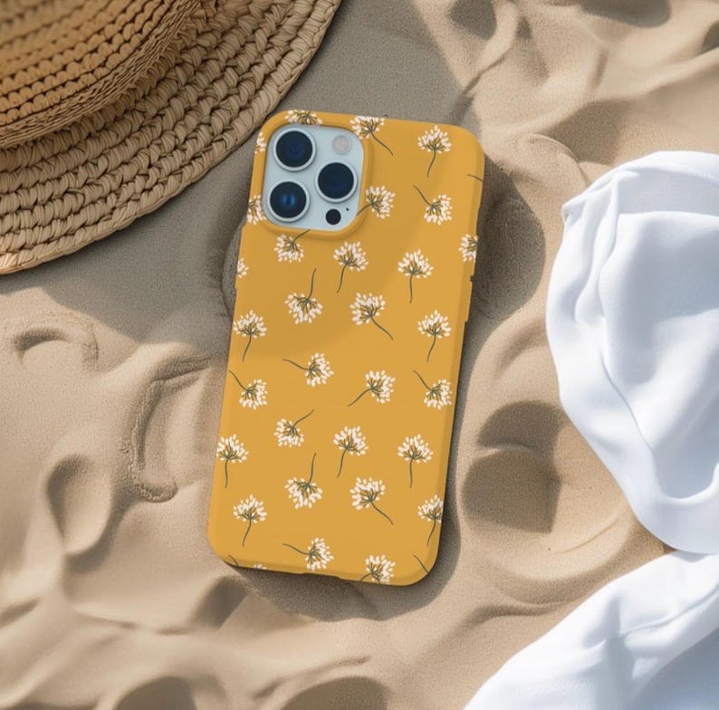 May include: A yellow phone case with a white floral pattern. The case has a camera lens cutout and a raised lip around the edges.