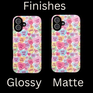 Op de afbeelding: Twee telefoonhoesjes met een Valentijnsdagthema. De hoesjes zijn bedekt met kleurrijke snoephartjes met verschillende boodschappen, waaronder "Ik hou van je", "Knuffel me", "Bel me" en "Marry Me". Een hoesje is glanzend en de andere is mat.