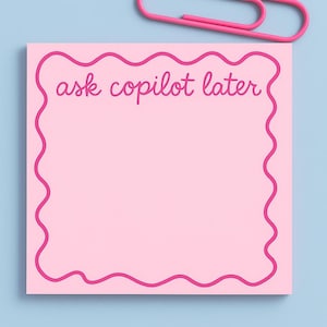 May include: A pink sticky note with a wavy pink border and the text "ask copilot later" in a handwritten style. A pink paper clip rests above the note on a light blue background.