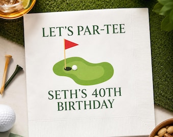 May include: White paper napkin with the text "LET'S PAR-TEE" and "SETH'S 40TH BIRTHDAY" in green. A golf course graphic with a red flag and golf ball is in the center. Golf balls and tees are visible.