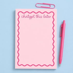 May include: A pink notepad with a wavy, magenta border and the text "chatgpt this later" in a cursive font. A magenta pen and paperclip are also present on a light blue background.