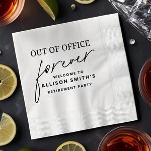 May include: White paper napkin with the text "OUT OF OFFICE forever WELCOME TO ALLISON SMITH'S RETIREMENT PARTY" in black. The napkin is surrounded by glasses of drinks and lemon slices.