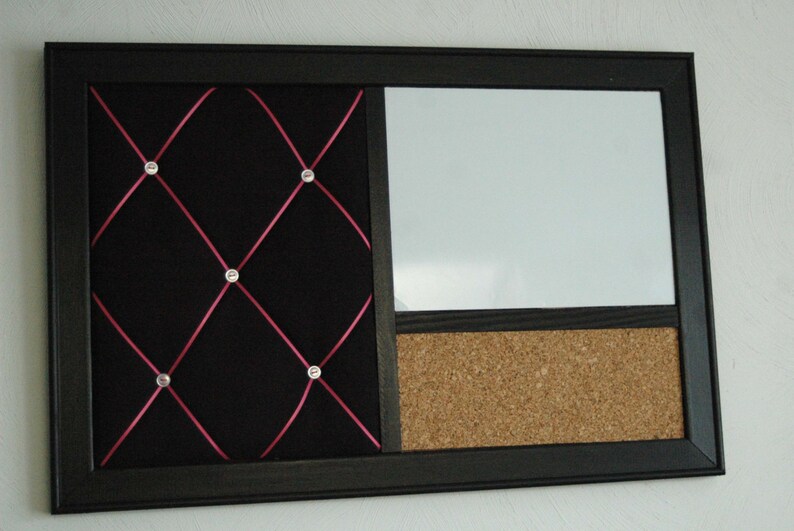 Puede incluir: Un tablero de anuncios negro enmarcado con tres secciones. La secci&oacute;n izquierda es de tela negra con cinta rosa entrecruzada y diamantes de imitaci&oacute;n plateados. La secci&oacute;n central es una pizarra blanca de borrado en seco. La secci&oacute;n derecha es un tablero de corcho.