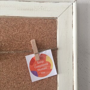 Puede incluir: Un tablero de corcho con un marco blanco y una pegatina que dice "Keep Commerce Human Etsy" con un dise&ntilde;o abstracto colorido.