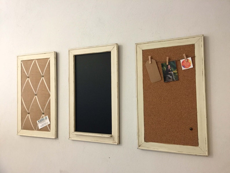 Może przedstawiać: Trzy oprawione tablice korkowe w białych ramach. Lewa tablica ma tło z pł&oacute;tna jutowego z białą wstążką i gwoździami. Środkowa tablica to czarna tablica kredowa. Prawa tablica ma powierzchnię korkową z fotografią i małą kartką przypiętą do niej.