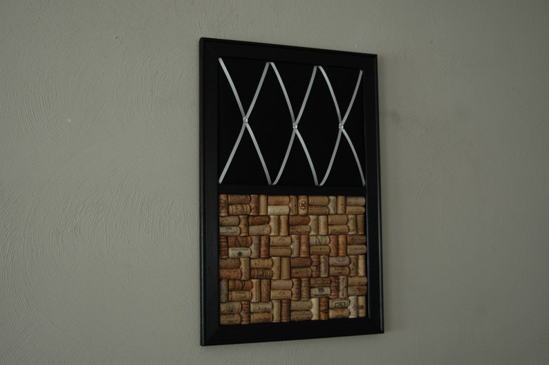 Puede incluir: Un tablero de corcho enmarcado en negro con una cinta blanca cruzando la secci&oacute;n superior y un patr&oacute;n de baldosas de corcho en la secci&oacute;n inferior.