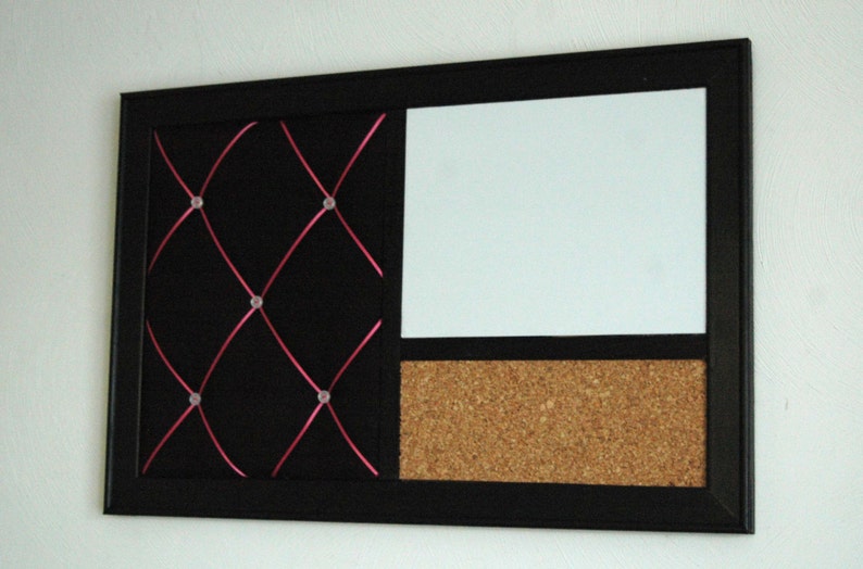 Puede incluir: Un tablero de anuncios negro enmarcado con tres secciones. La secci&oacute;n izquierda es de tela negra con cinta rosa cruzada y chinchetas transparentes. La secci&oacute;n del medio es blanca y la secci&oacute;n de la derecha es de corcho.