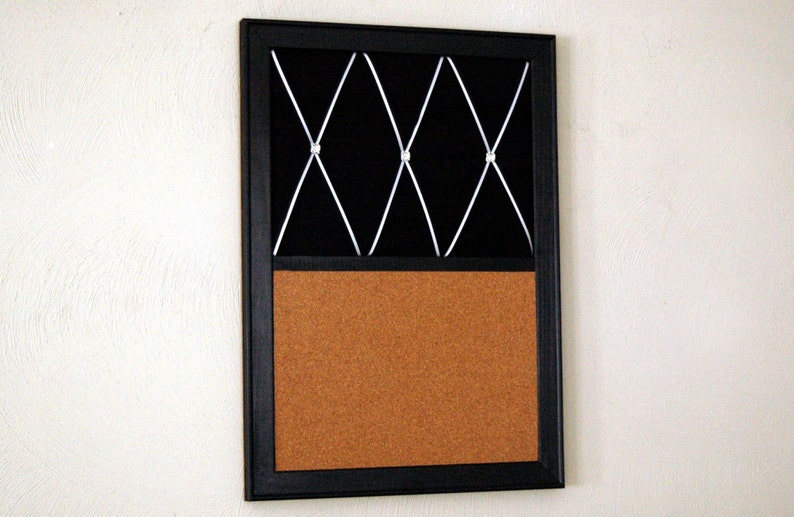 Puede incluir: Un tablero de corcho enmarcado en negro con un patr&oacute;n de cruz blanca en la mitad superior. La mitad inferior es un tablero de corcho.