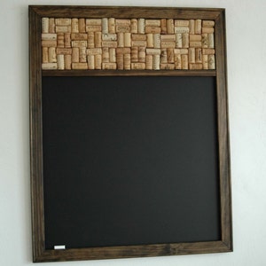 May include: A dark brown wooden framed chalkboard with a cork border. The cork border is made of many wine corks.
