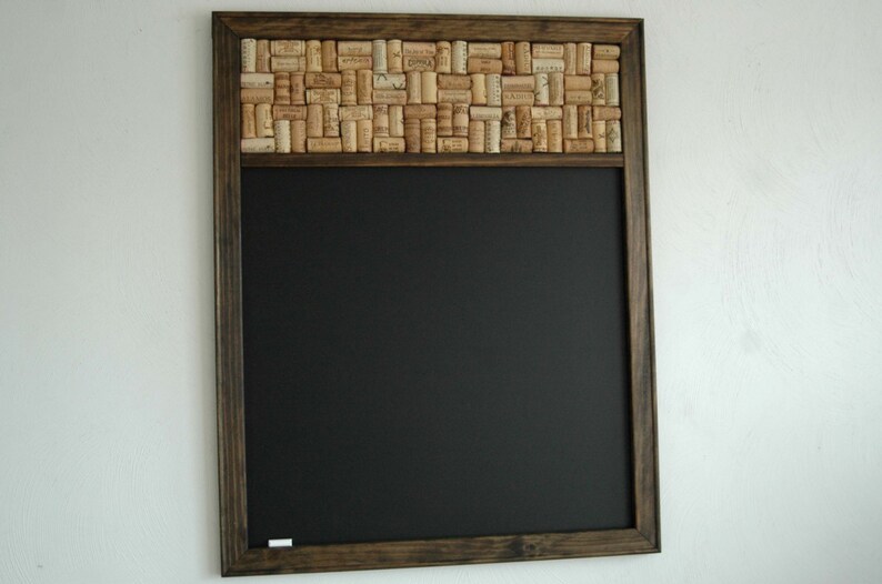 May include: A dark brown wooden framed chalkboard with a cork border. The cork border is made of many wine corks.