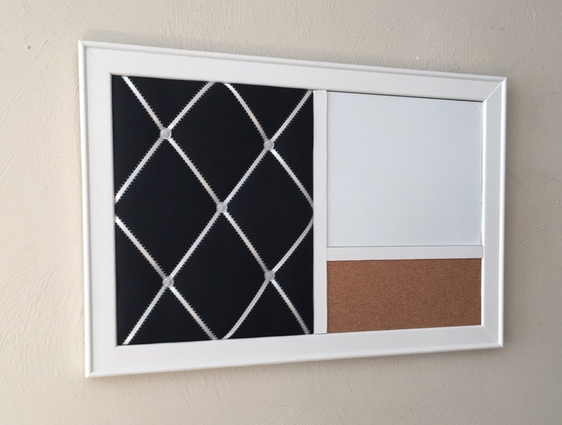 Puede incluir: Un tablero de corcho enmarcado en blanco con una secci&oacute;n de tela negra con costuras de diamante blancas y una secci&oacute;n de pizarra blanca de borrado en seco.