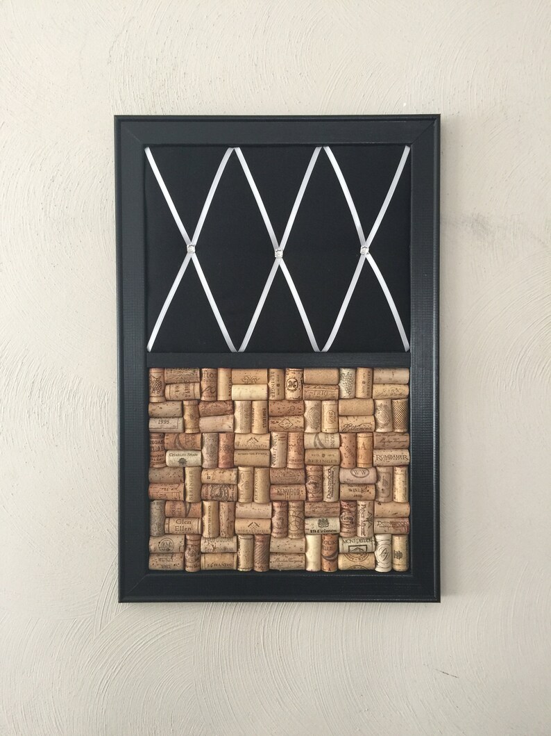 Puede incluir: Un tablero de corcho negro enmarcado con un patr&oacute;n de cruz blanca en la mitad superior y una cuadr&iacute;cula de corchos de vino en la mitad inferior.