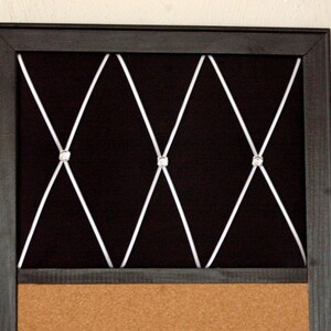 Puede incluir: Un tablero de corcho negro con marco negro, respaldo de terciopelo negro y un patr&oacute;n de cruz blanca con diamantes de imitaci&oacute;n. El tablero de corcho es perfecto para mostrar fotos, notas u otros recuerdos.