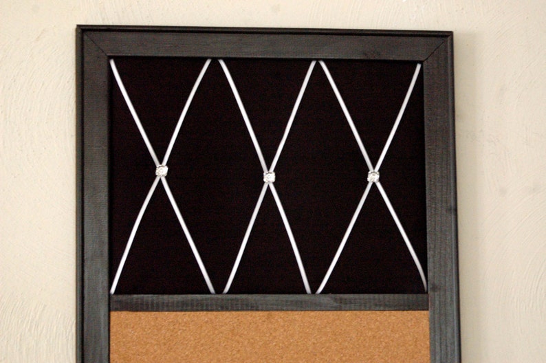 Puede incluir: Un tablero de corcho negro con marco negro, respaldo de terciopelo negro y un patr&oacute;n de cruz blanca con diamantes de imitaci&oacute;n. El tablero de corcho es perfecto para mostrar fotos, notas u otros recuerdos.