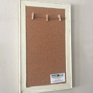 Puede incluir: Un tablero de corcho enmarcado en blanco con una cuerda de pinzas para la ropa en la parte superior. Una tarjeta de visita para "KatrinaCoastal etsy.com" est&aacute; fijada en la esquina inferior derecha.