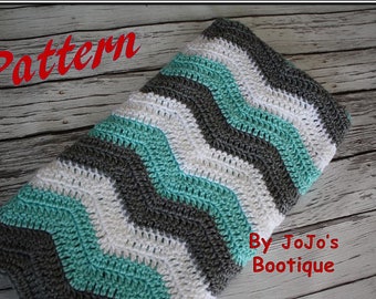 May include: A crochet baby blanket with a chevron pattern in teal, white, and grey. The blanket is made with a soft yarn and has a simple, modern design. The text "By JoJo's Boutique" is visible in the lower right corner of the image.