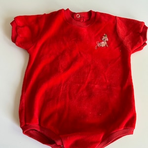 May include: Red short-sleeved onesie with a small embroidered reindeer design on the front.