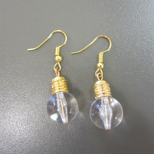May include: A pair of gold-tone earrings with clear glass lightbulb-shaped pendants.