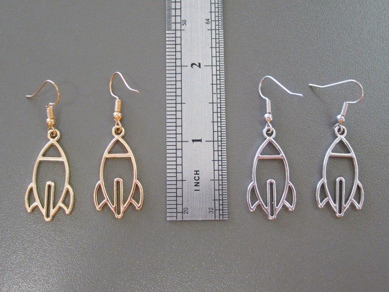 Pu&ograve; includere: Due paia di orecchini a forma di razzo. Un paio &egrave; color oro, l'altro &egrave; color argento. Gli orecchini sono lunghi circa 3,8 cm, con chiusura a gancio. Il design del razzo presenta un contorno dettagliato dell'astronave.