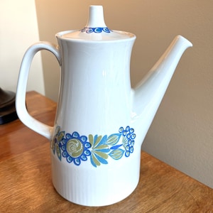 May include: A set of three ceramic mugs with a speckled, matte finish. The mugs are in shades of gray, white, and black. Each mug has a simple, modern design, perfect for coffee or tea.