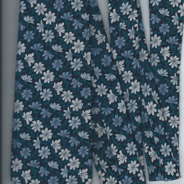 Neck tie by wembley made of wemlon polyester dark blue withwhite lite blue daisies crush proof 1960's