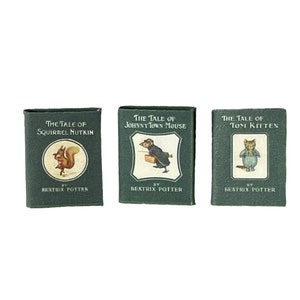 May include: Three miniature hardcover books with green covers and illustrations of animals. The titles are "The Tale of Squirrel Nutkin", "The Tale of Johnny Town-Mouse", and "The Tale of Tom Kitten".