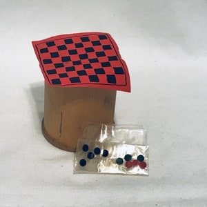 May include: A miniature checkerboard game set with a red and black checkerboard, a brown cardboard base, and black and red game pieces in a clear plastic bag.