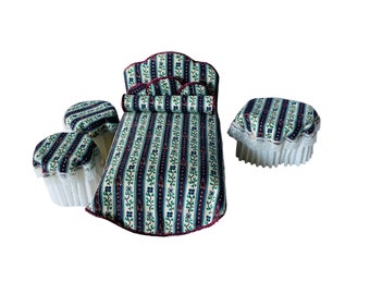 May include: A dollhouse bedroom set with a green and blue striped bed, a headboard, and three matching ottomans with white lace trim.