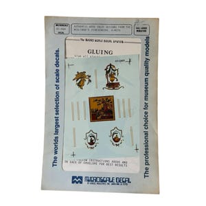 May include: A Microscale decal sheet for dollhouse miniatures. The sheet features authentic wood inlay designs from the mid-1800s firescreens. The text on the sheet reads "GLUING" and "The Micro Scale Decal System". The package also states "The world's largest selection of scale decals."