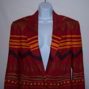 May include: A red blazer with a geometric pattern in orange, brown, and black. The blazer has a button closure and long sleeves.