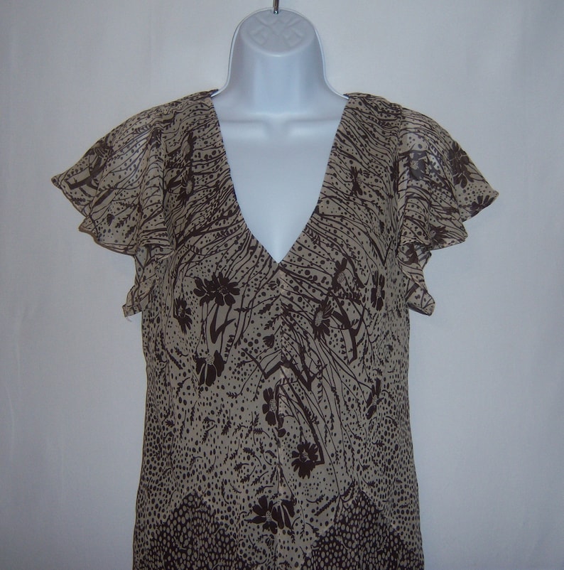 May include: A brown and beige sleeveless dress with a floral print and a V-neckline.