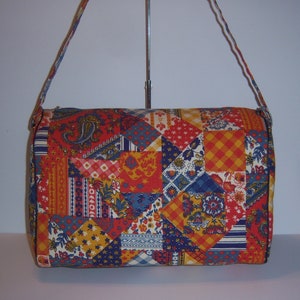 May include: A red, blue, and yellow patchwork fabric shoulder bag with a long strap.