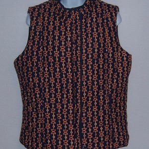 May include: A black quilted vest with a zipper closure and a geometric pattern of orange and white chains.